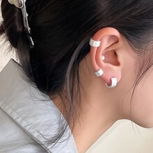 Close-up of minimalist matte white ear cuff set worn on earlobe and cartilage