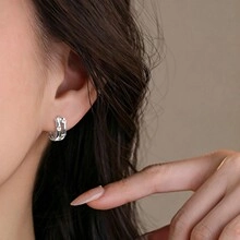 Close-up of liquid metal style silver ear cuff with irregular texture on model's ear