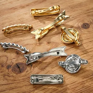 Elegant gold and silver metal hair clips set with spring mechanism on wooden background