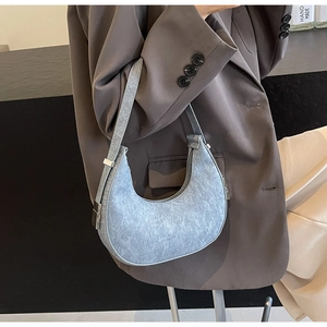 Detail view of the light blue crescent hobo bag with textured fabric and silver buckle