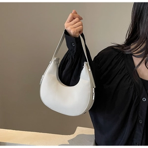 Detail of white crescent underarm bag showing smooth leather texture and silver zipper