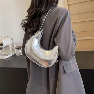 Fashionable silver metallic crescent underarm bag with a sleek minimalist shoulder strap