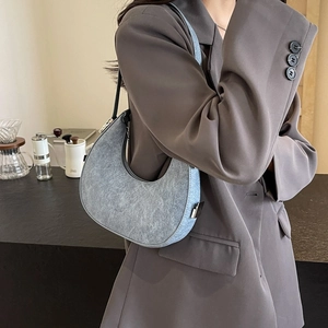 Minimalist light blue crescent shoulder bag for women styled with a grey blazer outfit