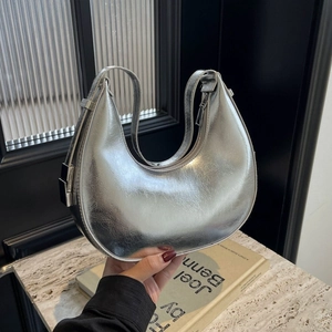 Metallic silver crescent underarm bag with pleated finish in Y2K fashion style