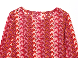Détail du haut en maille crochetée colorée avec motif ondulé rouge et rose et texture