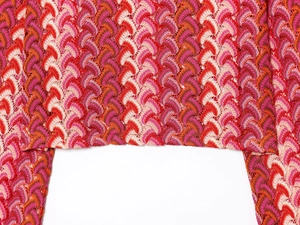 Gros plan sur un tricot au crochet coloré avec motifs ondulés et textures ajourées