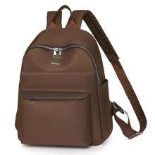 Side view of chocolate brown water-resistant laptop backpack with metal logo and flap pocket