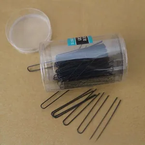Detail of professional black U-shaped hair pins in transparent cylindrical packaging