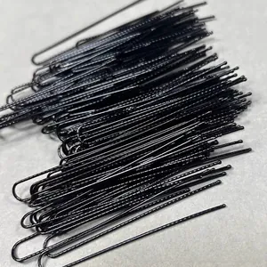 Close-up of black U-shaped metal hairpins with wavy design and protective ball tips