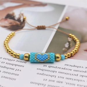 Detail of handmade woven heart bracelet with turquoise beads and adjustable cord