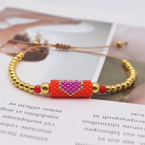 Macro shot of handmade Miyuki bead bracelet featuring a purple heart pattern on red beads