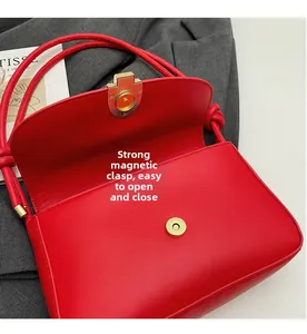 Detail view of red leather handbag showing the strong magnetic closure and interior space