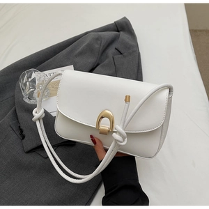 Detailed close-up of a white leather crossbody bag with a golden U-shaped metal lock