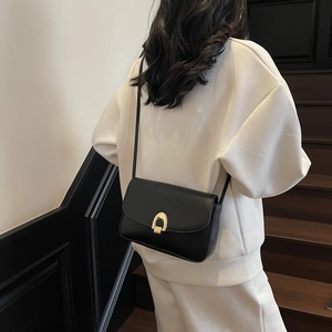 Classic black leather crossbody bag with a golden horseshoe buckle for women