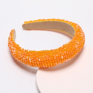 Close-up of sparkling orange crystal beads on a wide padded headband for parties