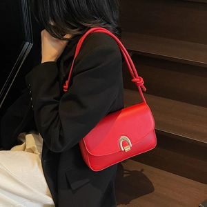 Classic red leather baguette shoulder bag with gold horseshoe buckle on model