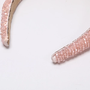 Close-up of handmade pink crystal beaded headband with satin edge detail