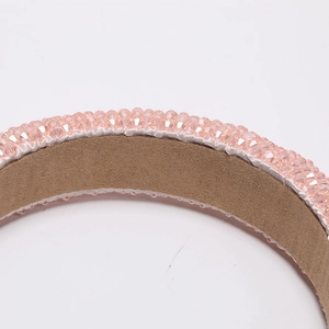 Macro detail of hand-beaded pink crystal headband with soft brown velvet lining