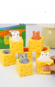 Detail showing hands squeezing yellow cheese cups with squirrels popping out for stress relief