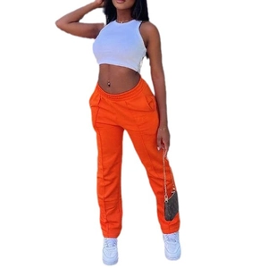 Women's chic high-waist orange trousers and white crop top set for casual fashion style