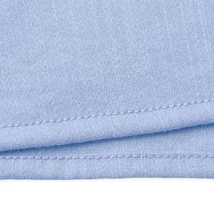 Detailed close-up of double-stitched hem and fabric texture on a light blue short sleeve shirt