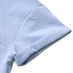 Close-up detail of light blue short sleeve shirt showing folded cuff and fabric texture