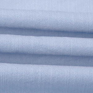 Detailed macro shot of premium light blue plain weave fabric with soft texture and drape