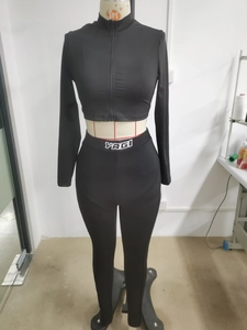 Detail of black two-piece knit set featuring front zipper and high waist YAGI leggings