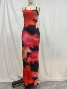 Détail d'une robe longue pour femme avec motifs floraux rouge et orange audacieux, coupe ajustée