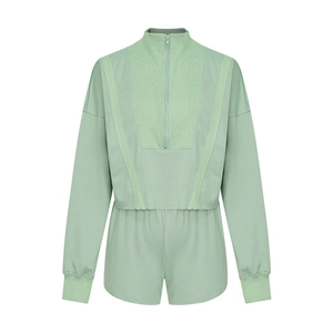 Détail du tissu en maille du sweat à manches longues zippé vert clair et du short assorti