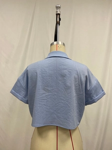 Detail view of the light blue short-sleeved shirt showing textured cotton linen back and seams