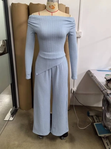 Detail of light blue ribbed knit texture on off-shoulder top and wide-leg trousers set