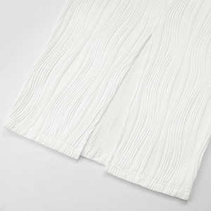 Detail of white knitted ripple dress with vertical pleats and hem slit design