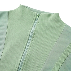 Détail d'un pull en maille vert menthe montrant le col zippé et la texture côtelée
