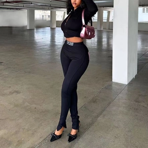 Women's two-piece black knit set with zip crop top and high waist slit leggings