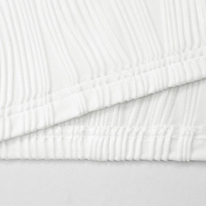 Close-up of white ribbed knit fabric showing fine vertical texture and quality stitching