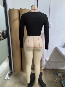 Vista posteriore di un crop top nero a maniche lunghe con texture in maglia a coste