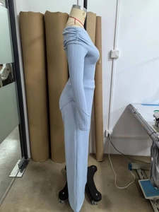 Side view of light blue knit off-shoulder top and wide leg pants on a mannequin