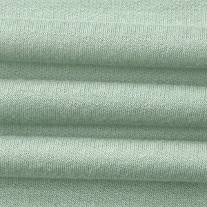 Gros plan détaillé sur la texture du tricot côtelé vert menthe et du coton doux