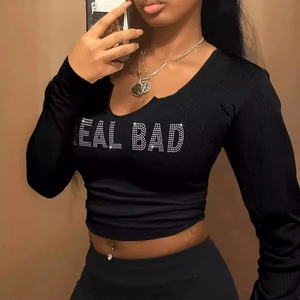 Dettaglio delle scritte in strass scintillanti REAL BAD sul crop top nero a costine