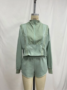 Détail d'ensemble en maille vert menthe avec col à demi-zip et panneaux à texture côtelée