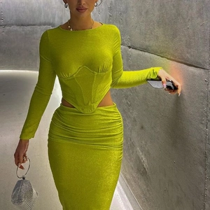 Detail von neongrünem Langarm-Crop-Top und gerafftem Midirock mit dezentem Glitzereffekt