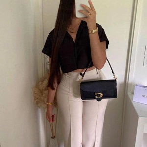 Women's black leather baguette bag with gold C buckle and matching shoulder strap