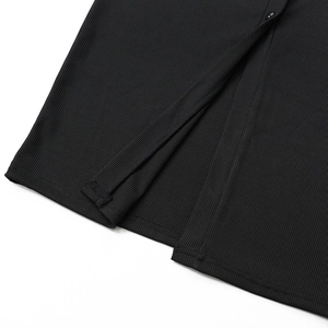Detail of black ribbed knit dress showing button placket and hem split craftsmanship