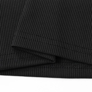 Detailed macro view of black ribbed knit fabric with professional double-needle stitching