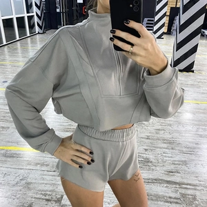 Détail de l'ensemble deux pièces en maille grise avec sweat à demi-zip et short de sport