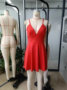 Detail of red sleeveless A-line dress featuring a deep V-neckline and slim straps