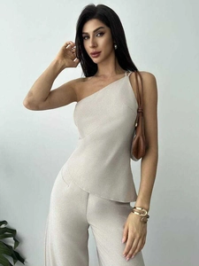 Détails du haut asymétrique beige à une épaule et du pantalon large à taille haute