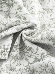 Detailed view of floral pattern fabric with elegant grey-green flowers on white canvas