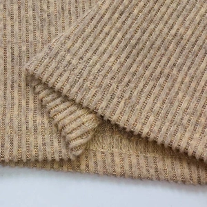 Vue macro détaillée du tissu en maille côtelée beige avec bordure en couture overlock